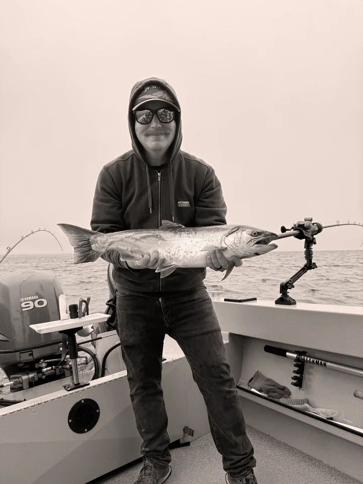 Andy Kipp holding a salmon aboard a fishing boat
